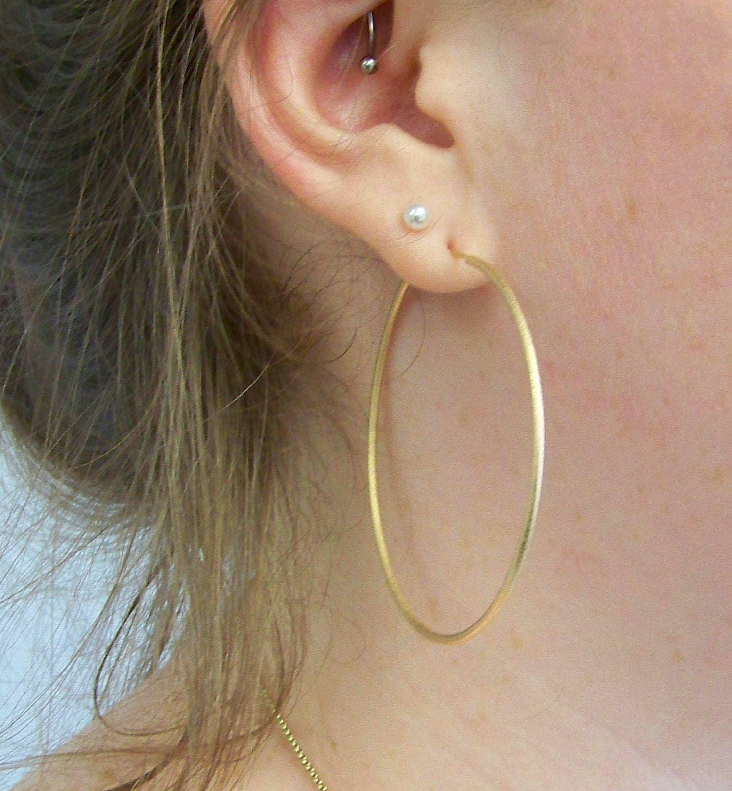 model wearing Sheila Fajl Lisa Featherweight Hoop Earrings in Polished Gold