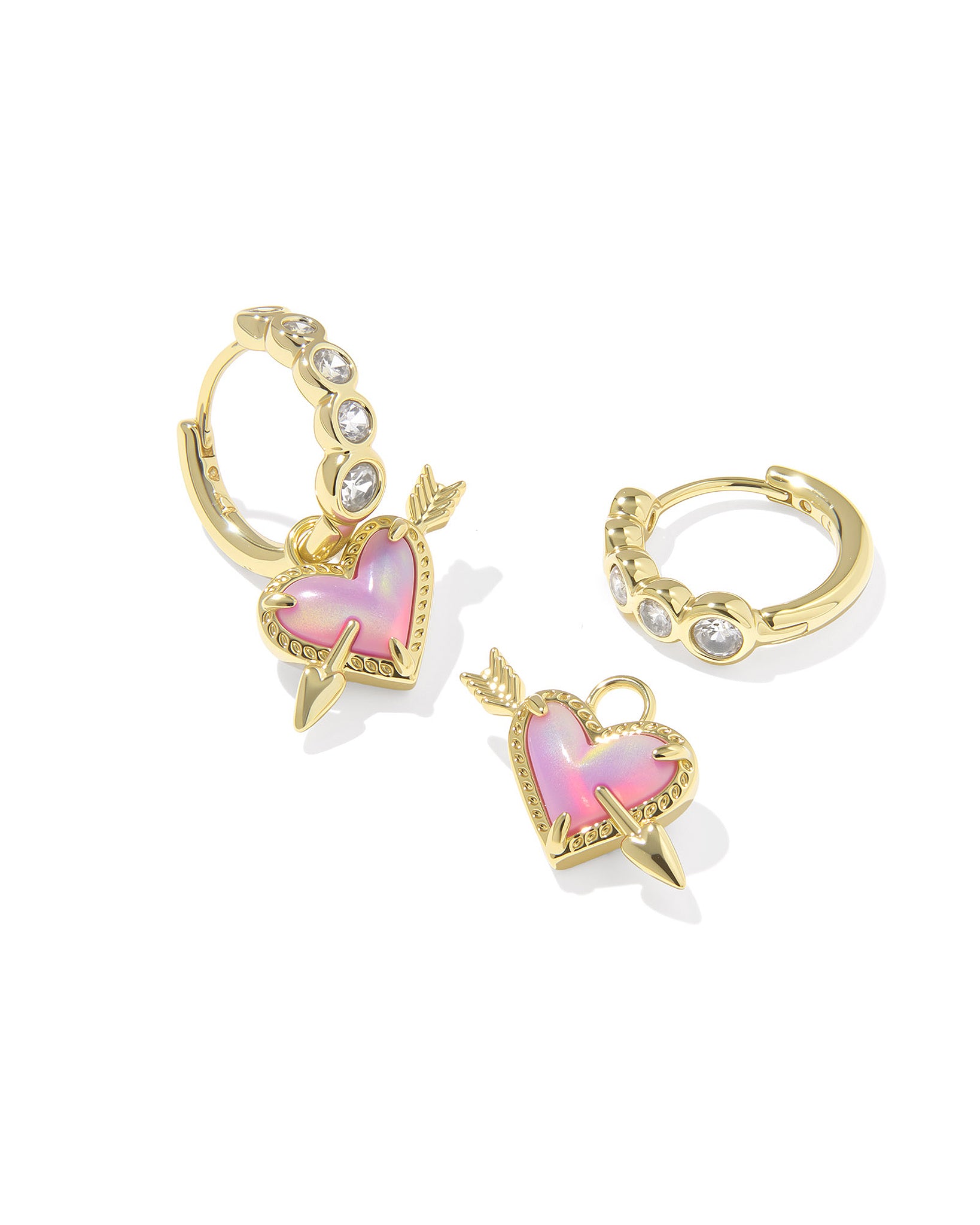 Pair of silver earrings with heart charm dangle with an arrow through it with pink accents on a white background