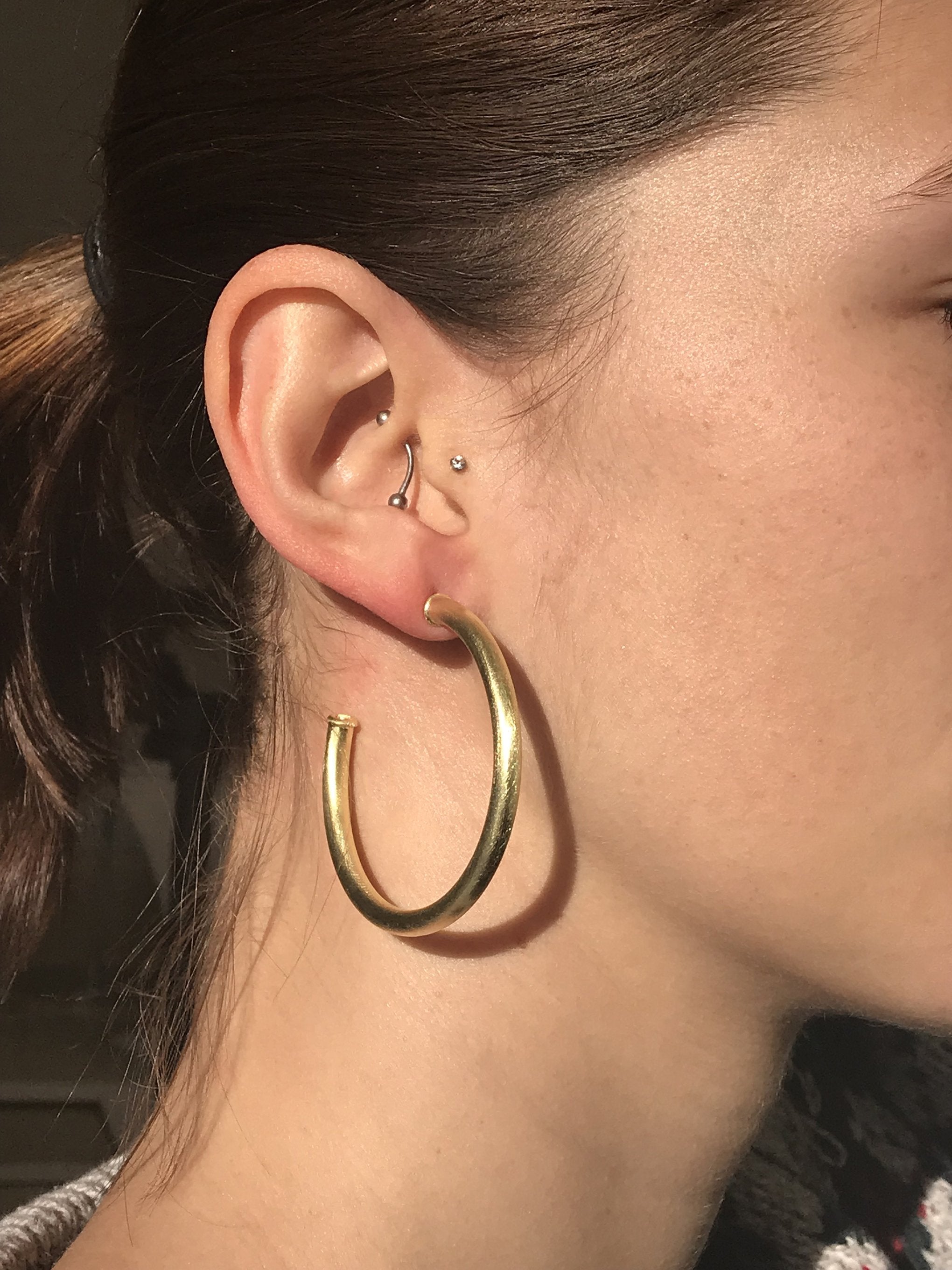 Close up of model wearing Sheila Fajl Smaller Favorite Tubular Hoop Earrings in Gold