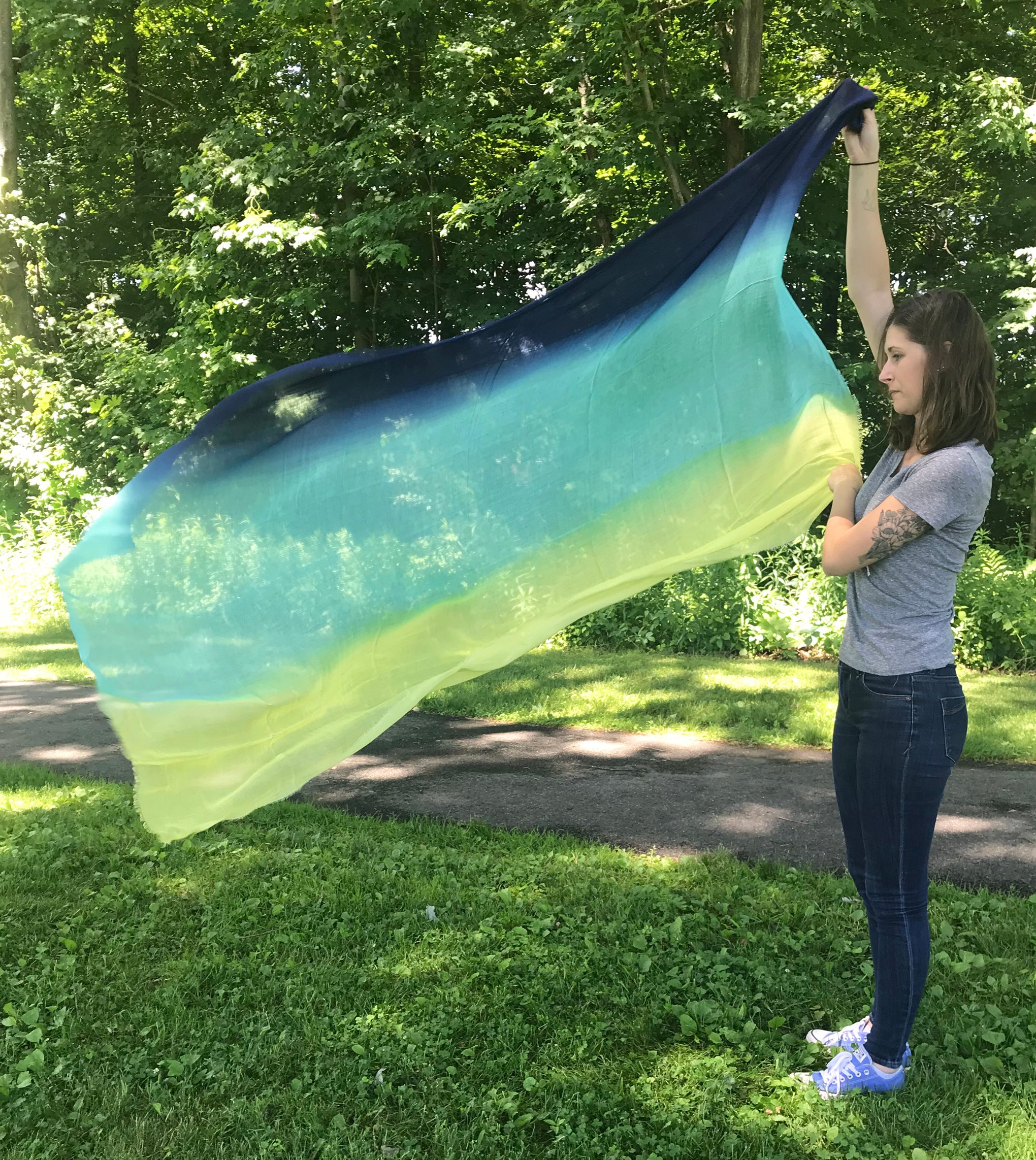 Model Holding Blue Pacific Dream Cashmere and Silk Scarf in Navy Bright Turquoise Yellow